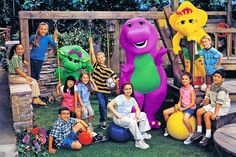 a group of children posing for a photo in front of an inflatable dinosaur