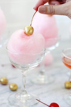 a person is holding a cherry sorbet in a wine glass