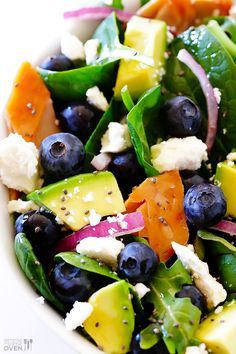 a salad with blueberries, carrots, cucumbers and feta cheese