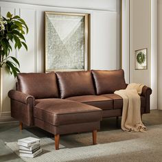 a living room with a couch, chair and potted plant