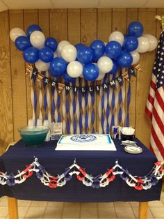 a blue table topped with a cake and balloons