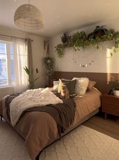 a bed room with a neatly made bed and lots of plants on the wall above it