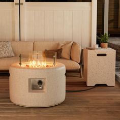 a fire pit sitting on top of a wooden floor next to a couch and table