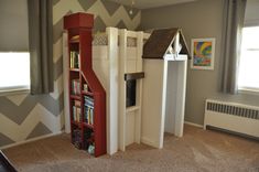 a child's bedroom with a bookcase and bookshelf in the corner