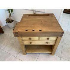 a wooden table with drawers on top of it and a potted plant in the background