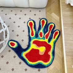 a colorful hand rug on the floor next to a white couch