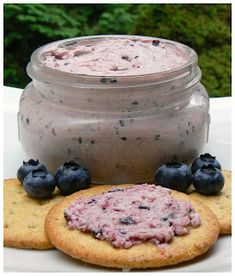 a cookie with blueberries on it next to a jar of dip