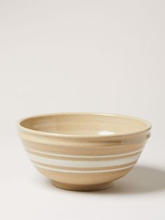 a white and beige striped bowl sitting on top of a table