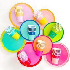 colorful plates and cups are stacked on top of each other in the shape of a circle