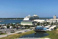 a cruise ship is docked in the water next to a large building and parking lot