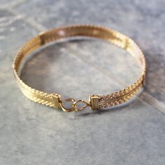 "A bold, substantial bracelet handcrafted with ten strands of 14kt gold filled wire in a classic wire-wrap style. Three strands of twist wire on each side, flanking four strands of plain square wire in the middle. Dress it up or down--it's definitely a wear-with everything accessory! Also stackable with so many of my other bracelet styles. There's nothing like an armful of affordable gorgeousness to make you feel great! The built-in hook and eye-type clasp is easy to get on and off. This bracele Artisan Wire Wrapped Adjustable Bracelets, Artisan Adjustable Bangle Bracelets, Adjustable Double Strand Bracelet As Gift, Adjustable Double Strand Bracelet For Gift, Adjustable Double Band Gold Bracelet, Adjustable Double Band Gold Bracelets, Adjustable Gold Artisan Choker, Gold Adjustable Double Band Bracelet, Adjustable Artisan Gold Choker