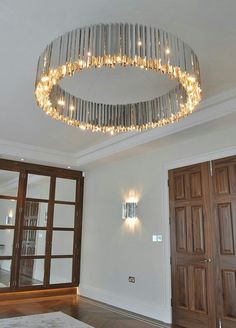 a chandelier hanging from the ceiling in a room with wooden doors and windows