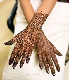 a woman's hand with henna tattoos on it