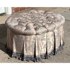 a round ottoman sitting on top of a sidewalk