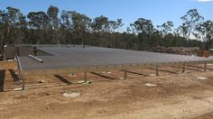 a man standing on top of a metal roof in the middle of a dirt field