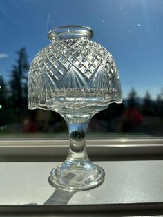 a clear glass vase sitting on top of a window sill