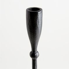 a tall black vase sitting on top of a table