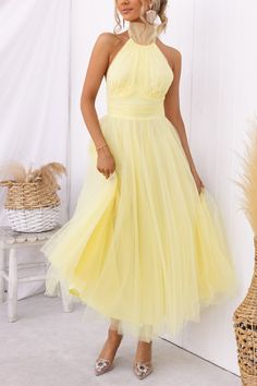 a woman in a yellow dress posing for the camera