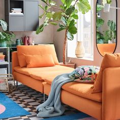 a living room filled with furniture and a large mirror on the wall next to a window