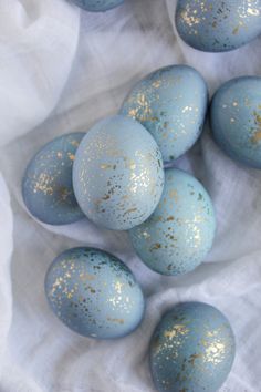 blue and gold speckled eggs on white fabric