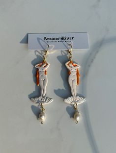 Step into a world of timeless beauty with these Birth of Venus earrings, inspired by William-Adolphe Bouguereau's 1879 masterpiece. Capturing the essence of elegance, these earrings evoke the mythical charm and artistic grace of Venus herself. For those who appreciate classical artistry and the draw of mythological tales. 100% hypoallergenic. 3.5 inches in length. Handmade from Sculpey premo, liquid clay, mica powder and semi-precious freshwater pearls. Includes matte varnish to keep art protect Elegant White Jewelry With Artistic Design, Elegant Artistic Drop Earrings Jewelry, Elegant Artistic Drop Earrings, Artistic White Drop Earrings, Elegant Artistic Design Drop Earrings, Statue Clay, William Adolphe, Liquid Clay, Birth Of Venus