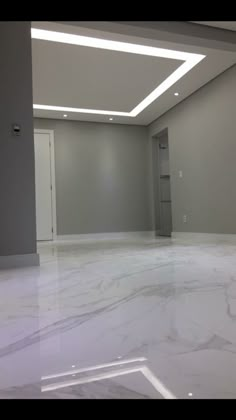 an empty room with white marble floors and walls