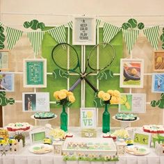 a table topped with cakes and cupcakes next to a wall covered in pictures