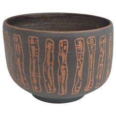 a black and brown bowl with designs on it