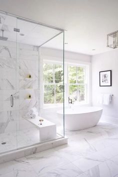 a large white bathroom with marble flooring and glass shower stall, tub and sink