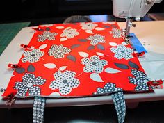 the sewing machine is next to an orange and white flowered fabric with black dots on it