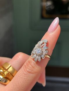 Playful yet elegant, this vintage Retro “Plume” Cluster Ring is a remarkable statement piece. Crafted circa 1940’s, this ring is a glimmering example of the ways 1940’s jewelry continued some of the Belle Epoque design traditions. Note the striking 14 carat yellow gold body of the ring, which juxtaposes beautifully against the 14 carat white gold top. Also beautiful are the cluster of vivid white miniature diamonds, which are arranged in a labyrinthine halo around the pièce de resistance – a gor Vintage Rose Cut Diamond Jewelry For Vintage Events, Vintage Ring Jewelry For Vintage Events, Art Deco Diamond Cluster Ring With 17 Jewels, Vintage Marquise Diamond Jewelry, Vintage Platinum Cluster Jewelry, Vintage Marquise Diamond Cut Rings, Vintage Marquise Diamond Ring With Prong Setting, Vintage Marquise Jewelry With Prong Setting, Vintage Jewelry With Single Cut Diamonds For Vintage Events