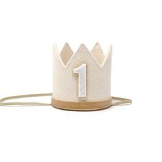 a white and gold crown with the number one on it's side, against a white background