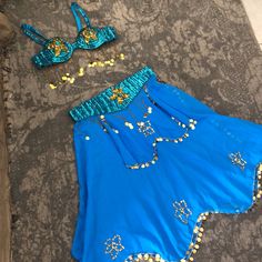 two pieces of clothing laying on top of a floor next to each other with gold and blue sequins