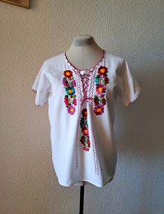 Very old women blouse with beautiful embroidered flowers and lace up at the front. Made from thick white cotton fabric. Very good vintage condition. Flat measurements: armpit to armpit  - 55 cm/21.6'' length - 65 cm/25.6'' fits like size - M/L White Cotton Peasant Top For Festival, White Cotton Festival Peasant Top, Folk Style Cotton Blouse With Machine Embroidery, Cotton Folk Blouse With Machine Embroidery, Vintage White Embroidered Top For Festivals, White Vintage Embroidered Top For Festival, Vintage Cotton Top With Floral Embroidery, Vintage Embroidered Short Sleeve Peasant Top, Vintage White Embroidered Cotton Top