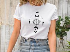 Mystic Moon And Sun T-shirt, Mystical Moon Phase T-shirt, Moon Phase T-Shirt, Vintage Moon T-shirt ,Boho Moon T-shirt,Celestial Moon T-shirt ❀DETAIL❀ For printing, we use Bella Canvas and Gildan SoftStyle brand shirts, which are the best in the industry. *Bella Canvas -unisex size -4.2 oz. -Solid colors are 100% Combed Cotton and Ring-Spun Cotton. -Athletic Heather 90% Combed and Ring-Spun Cotton, 10% Polyester -All Heather CVC Colors 52% Combed and Ring-Spun, 48% Polyester *Gildan SoftStyle -un White Moon Print T-shirt For Summer, Bohemian Cotton T-shirt With Sun And Moon Design, Bohemian Short Sleeve T-shirt With Sun And Moon Design, Festival Graphic Tee With Moon Print, Casual Summer T-shirt With Sun And Moon Design, Bohemian Summer Tops With Moon Print, Bohemian Short Sleeve T-shirt With Moon Print, Summer Crew Neck T-shirt With Sun And Moon Design, Moon Tshirt