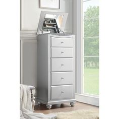 a white chest of drawers sitting next to a window