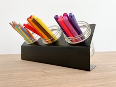 several colored pencils are in a glass holder