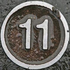 the number thirteen is written in white on top of black ground with mud around it