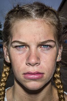 a woman with freckles on her face and blue eyes is looking at the camera