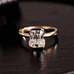 a close up of a ring on a table with a diamond in the center,