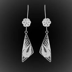 These long and hanging earrings highlight the face by giving it radiance thanks to its material since they are made of solid silver 925. They are formed of a fine and very pretty little flower, decorated with a small silver pearl, to which is hung a triangle slightly asymmetrical and decorated in its heart with very fine embroidery. Pretty curves and round shapes make up this pretty pattern full of brilliance, as the solid shapes bring a lot of relief and play with light. They measure 6.5 cm and The Bermuda Triangle, Fine Embroidery, Bermuda Triangle, Silver Embroidery, Solid Shapes, Filigree Jewelry, Pretty Patterns, Hanging Earrings, Silver Pearls