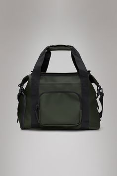 a green and black duffel bag on a grey background with the handles folded down