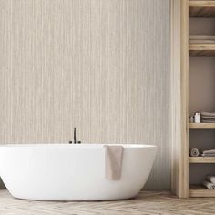 a white bath tub sitting on top of a wooden floor next to a book shelf