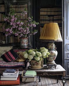 a living room filled with lots of furniture and flowers on top of a coffee table