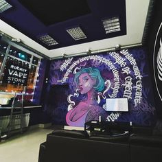 a large mural on the wall in an office space with purple and black graphics above it