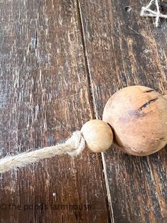 a piece of wood that has some kind of ball on it and rope attached to it