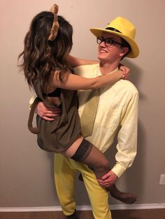 a man and woman dressed up as the flint family, one is wearing a yellow hat