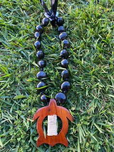 "18\" Wooden Turtle Pendant Black Kukui Nui Lei Necklace Beads:  Approximately 1 inch in diameter Each piece has a distinct character of its own, for no two are exactly alike in color, shape, and size. Hand-crafted, sanded and polished by Native artisans Adjustable Black Fine Satin Ribbon Tie" Themed Black Jewelry As Gift, Themed Black Jewelry Gift, Hand-strung Pendant Jewelry As A Gift, Black Round Pendant Keepsake Jewelry, Adjustable Black Themed Necklace, Large Beads Pendant Necklace Gift, Vintage Black Beads For Gifts, Large Beads Pendant Necklace For Gift, Spiritual Black Beads Round Jewelry