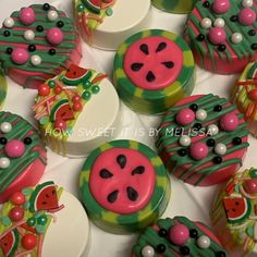 there are many decorated cupcakes on the table with watermelon designs and pearls