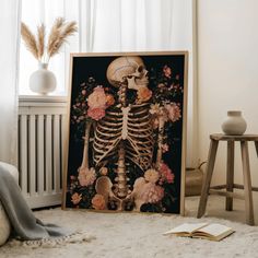 a skeleton with flowers on it sitting in front of a window next to a book